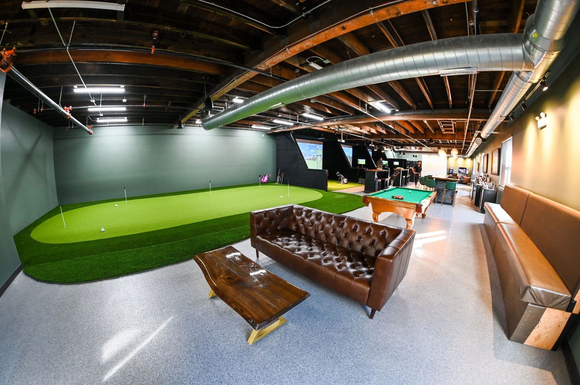 Inside Ravenswood Golf Club: putting green, lounge seating, pool table and Trackman simulator bays